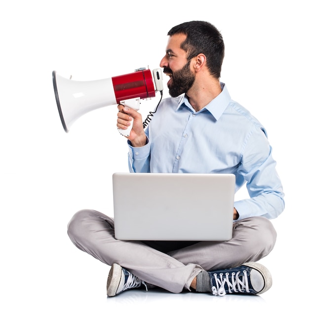 Homem com laptop gritando por megafone