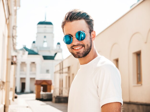 Homem com óculos de sol, vestindo camiseta branca posando