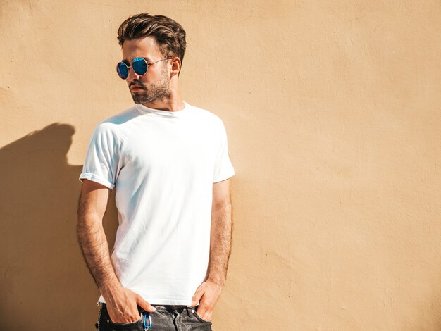 Homem com óculos de sol, vestindo camiseta branca posando