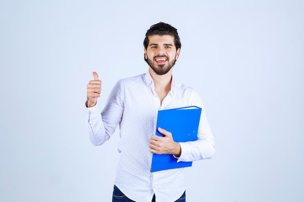 Homem com pasta azul mostrando sinal de satisfação