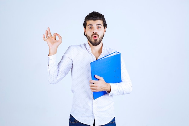 Homem com pasta azul mostrando sinal de satisfação