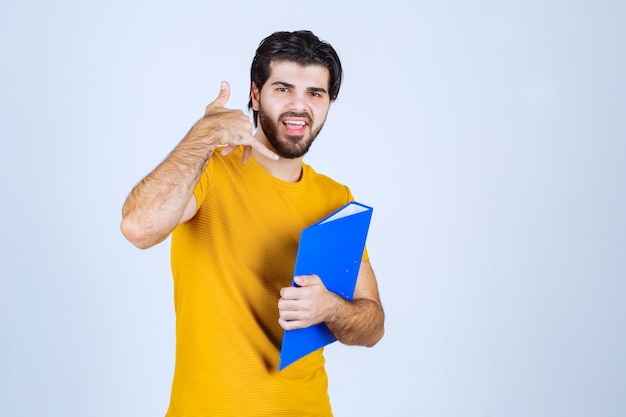 Homem com pasta azul pedindo para ligar.