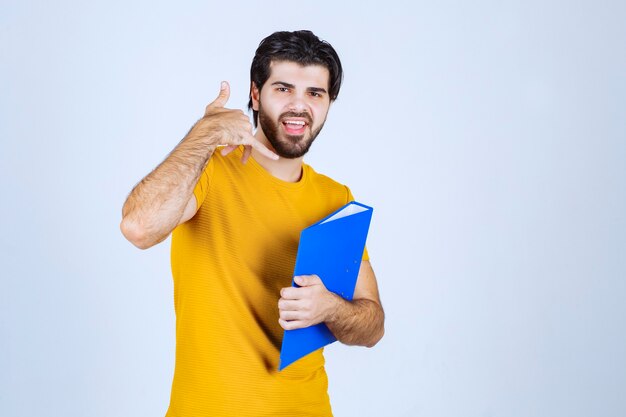 Homem com pasta azul pedindo para ligar.