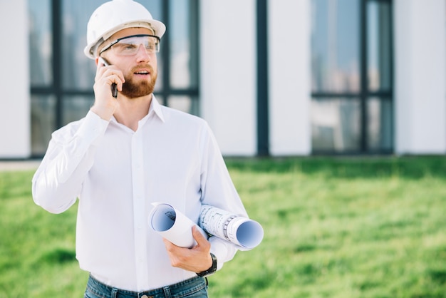 Foto grátis homem com planos falando no telefone