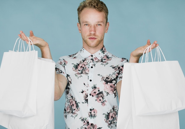 Homem com sacolas de compras em um fundo azul