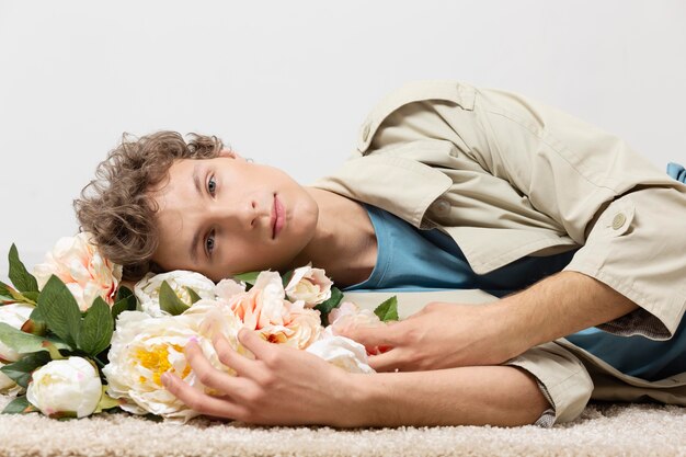 Foto grátis homem com sobretudo segurando flores