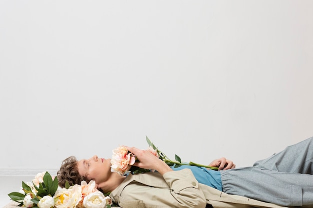 Foto grátis homem com sobretudo segurando flores