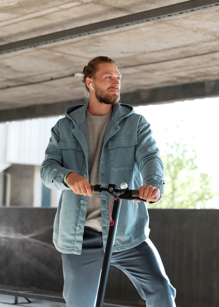 Homem com sua scooter em um estacionamento coberto