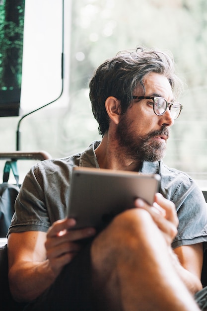 Foto grátis homem com tablet desviando o olhar