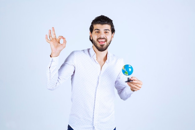 Homem com um mini globo curtindo