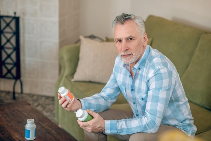 Foto grátis homem com uma camisa xadrez segurando suplementos dietéticos