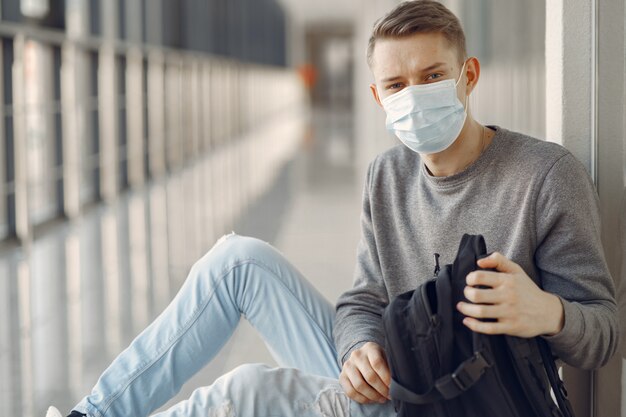 Homem com uma máscara sentado no corredor do hospital