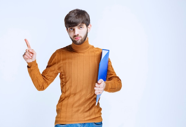 Homem com uma pasta azul mostrando o lado esquerdo.