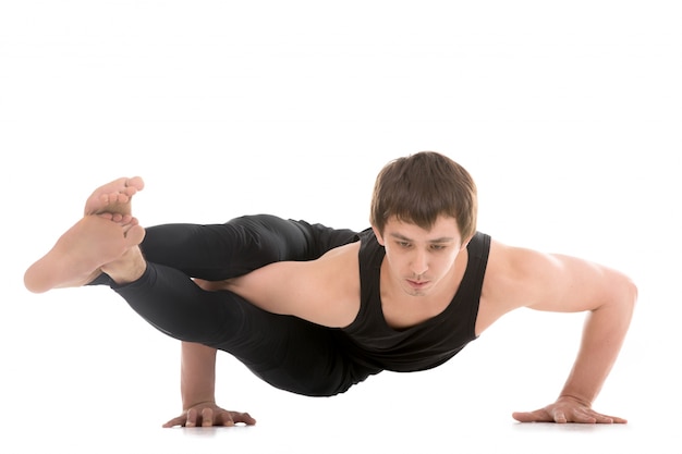 Homem com uma postura de yoga difícil