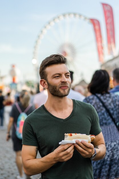 homem comendo comida de rua. hotdogs de rua