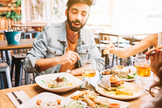 Homem comendo pratos diferentes de comida