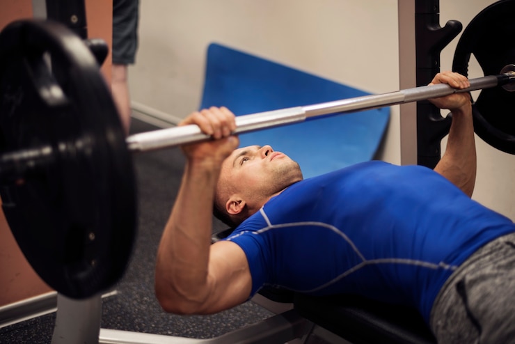 Foto grátis homem concentrado fazendo exercícios no banco de musculação