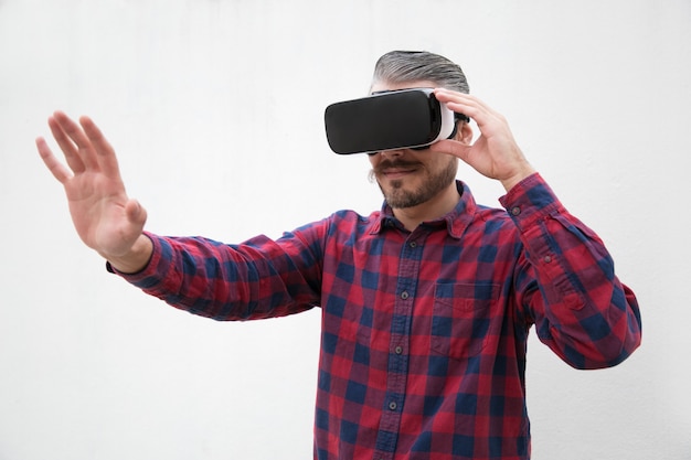 Homem concentrado usando fone de ouvido de realidade virtual