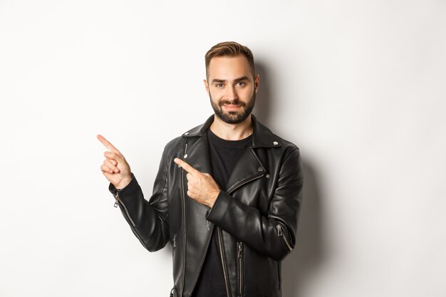 Homem confiante em uma jaqueta de couro preta, apontando o dedo esquerdo na oferta promocional