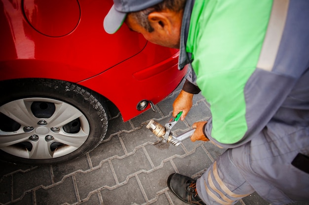 Homem consertando carro vermelho