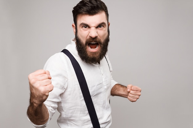 Homem considerável novo rude irritado que shouting sobre o branco.