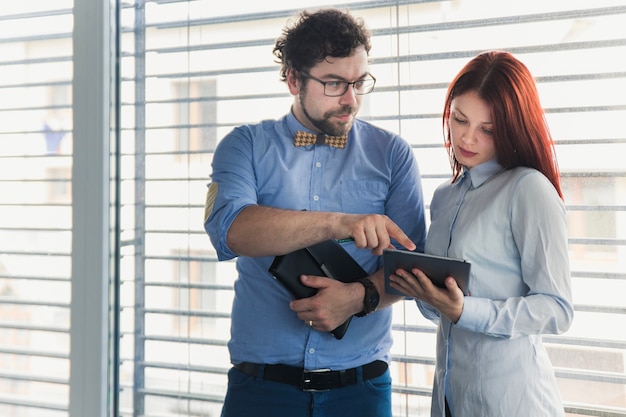 Foto grátis homem consultando jovem colega de trabalho