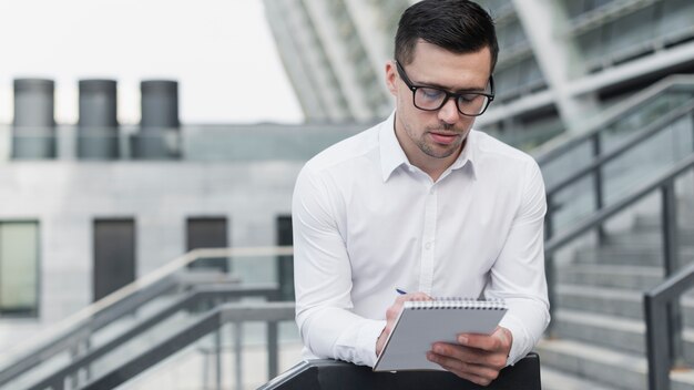 Homem corporativo, escrevendo no bloco de notas