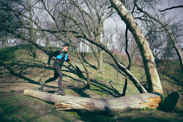 Foto grátis homem correndo em um parque ou floresta contra o espaço das árvores