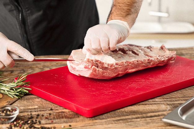 Homem cozinhando bife de carne na cozinha