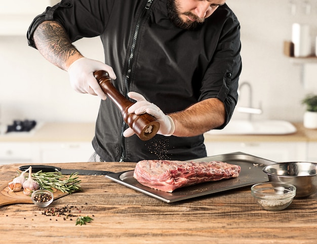 Homem cozinhando bife de carne na cozinha