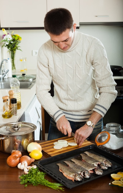 homem cozinhando peixe truta