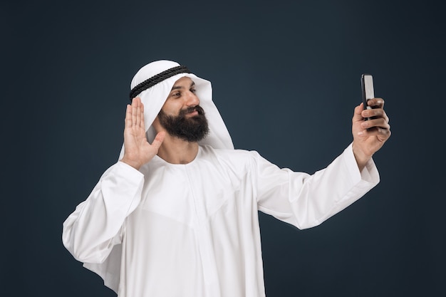 Foto grátis homem da arábia saudita em parede azul escura