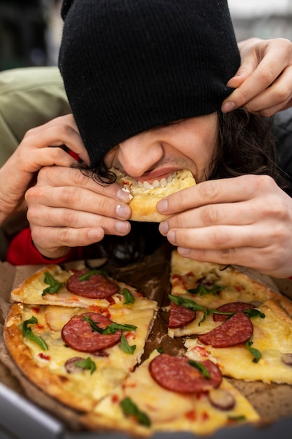 Foto grátis homem de alto ângulo comendo pizza