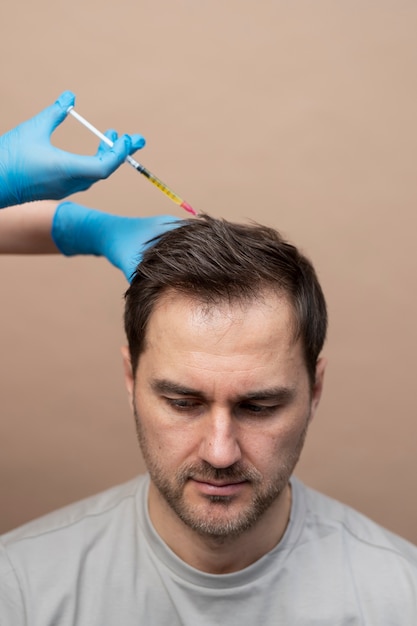 Foto grátis homem de alto ângulo recebendo injeção de prp para alopecia