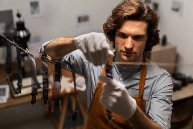 Foto grátis homem de alto ângulo revelando fotos