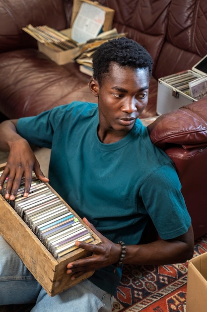 Homem de alto ângulo segurando discos de vinil