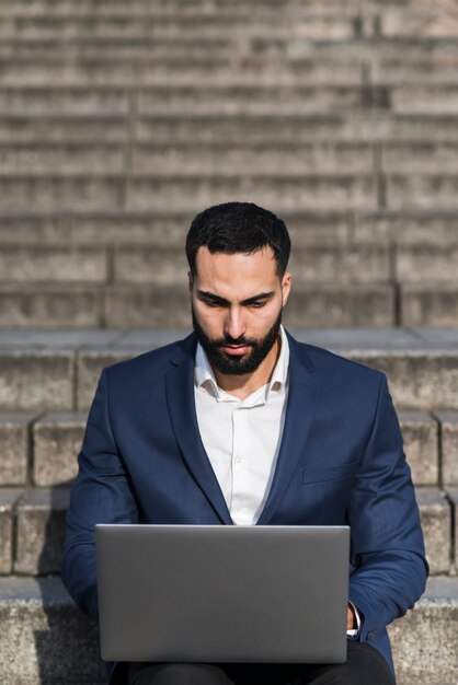 Homem de alto ângulo, trabalhando no laptop