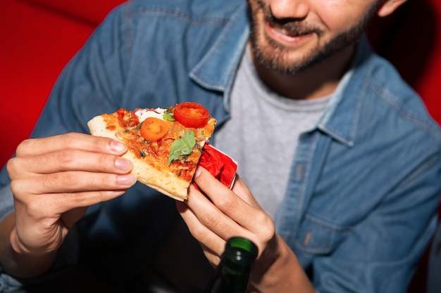 Foto grátis homem de ângulo alto a comer pizza.