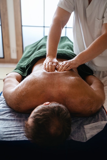Foto grátis homem de ângulo alto a fazer massagem.