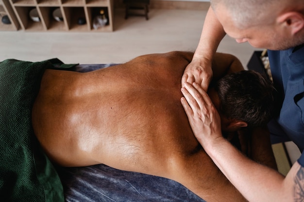 Homem de ângulo alto a fazer massagem.