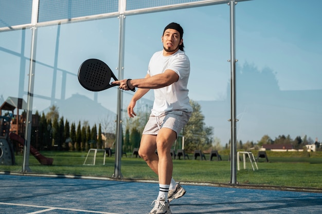 Homem de baixo ângulo jogando padel