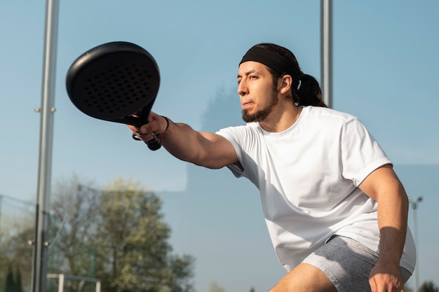 Homem de baixo ângulo jogando padel