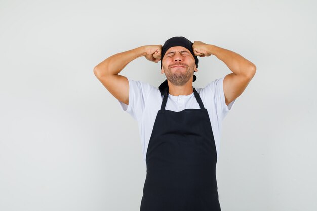 Homem de Baker segurando os punhos na cabeça em uma camiseta