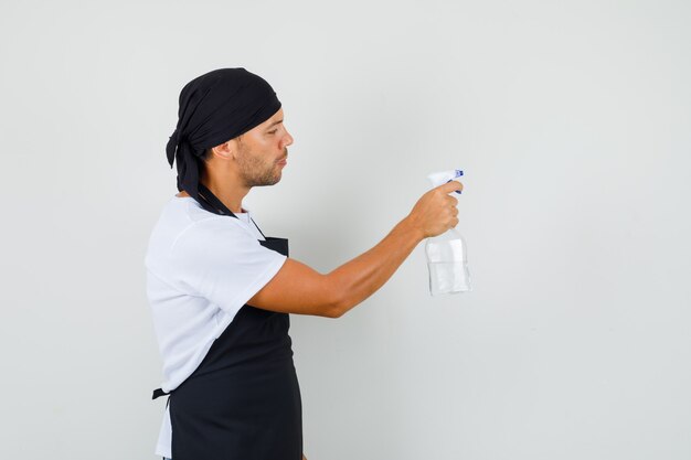 Homem de baker segurando um frasco de spray anti-séptico em uma camiseta