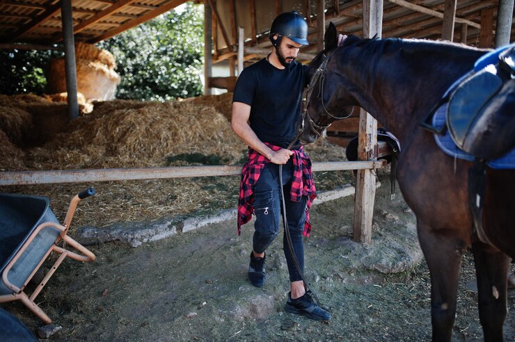 Foto grátis homem de barba alta árabe usa capacete preto com cavalo árabe