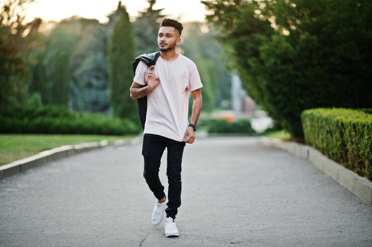 Foto grátis homem de barba indiana elegante em camiseta rosa com jaqueta de couro preta no ombro modelo da índia andando na cidade à noite