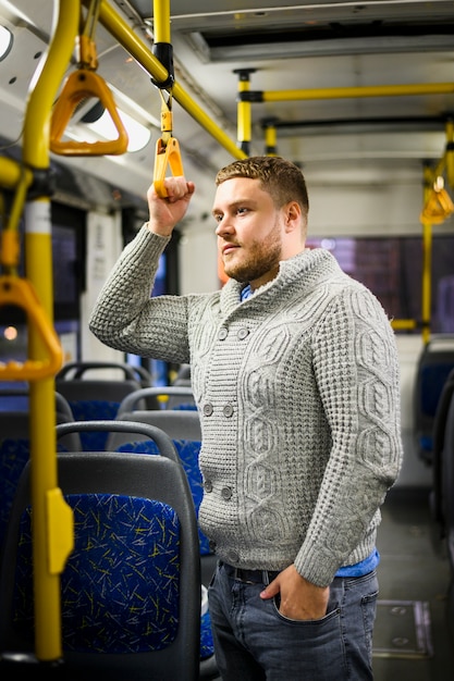 Foto grátis homem de blusa cinza e calça jeans, viajando de ônibus