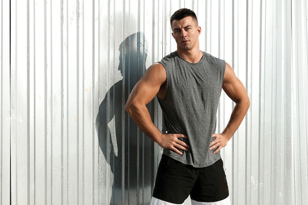 Homem de boa musculatura. Retrato de homem bonito atleta fitness posando ao ar livre