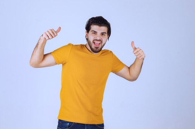 Homem de camisa amarela aparecendo com o polegar