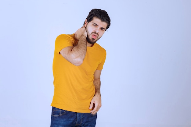 Homem de camisa amarela dando poses sedutoras e atraentes.